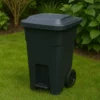 A photograph captures a black wheeled trash bin wi
